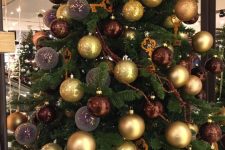 a glam Christmas tree decorated with brown, gold and mauve ornaments, keys and garlands is a cool decoration