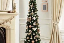 a glam pencil Christmas tree decorated with white, silver and pink ornaments and pink leaves on top