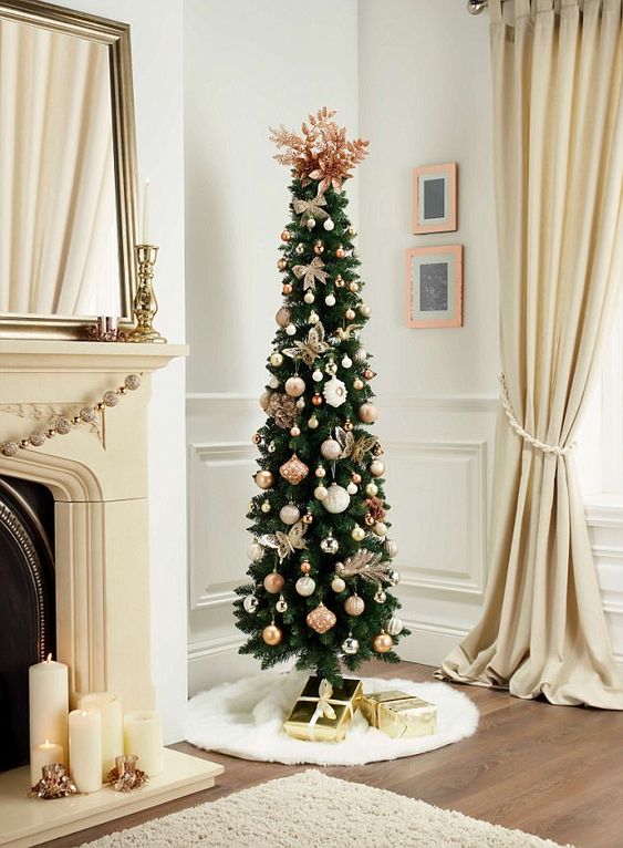 a glam pencil Christmas tree decorated with white, silver and pink ornaments and pink leaves on top
