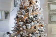 a glam woodland Christmas tree with burlap garlands, gold, brown, grey ornaments, snowflakes, deer and sleigh ornaments