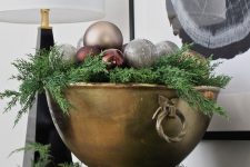 a large vintage bowl with evergreens, burgundy, grey and copper ornaments is a cool centerpiece