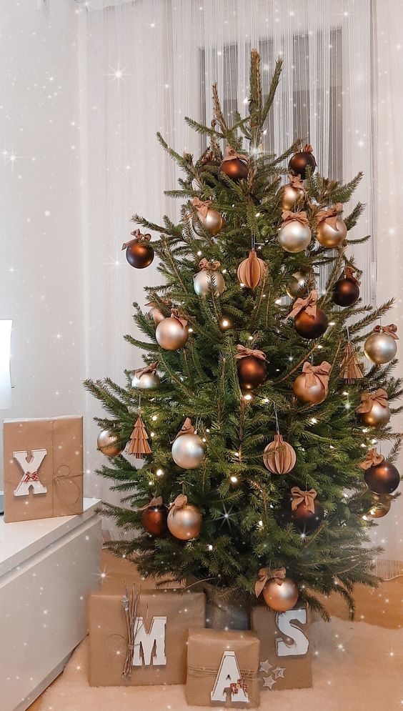 a lovely Christmas tree styled with silver and brown ornaments, paper ones and lights is amazing