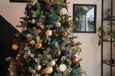 a lovely Christmas tree with snowy pinecones, lights, gold, brown, copper and silver ornaments is adorable