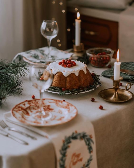 a lovely christmas tea party table with a bundt cake, evergreens, vintage porcelain and printed linens
