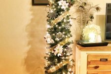 a lovely skinny Christmas tree with snowflakes, faux flowers, pinecones, snowflakes, ribbons and lights
