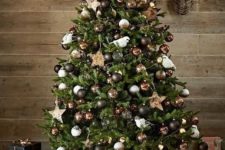 a magical Christmas tree styled with black, white and brown ornaments, stars, lights and faux birds is wow