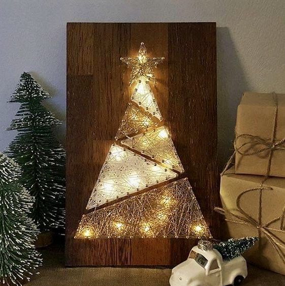 a modern Christmas string art piece showing a tree composed of triangles, with a star topper and lights is adorable