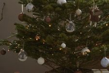 a modern Christmas tree with lights, silver, white and brown ornaments is a cool and catchy decor idea