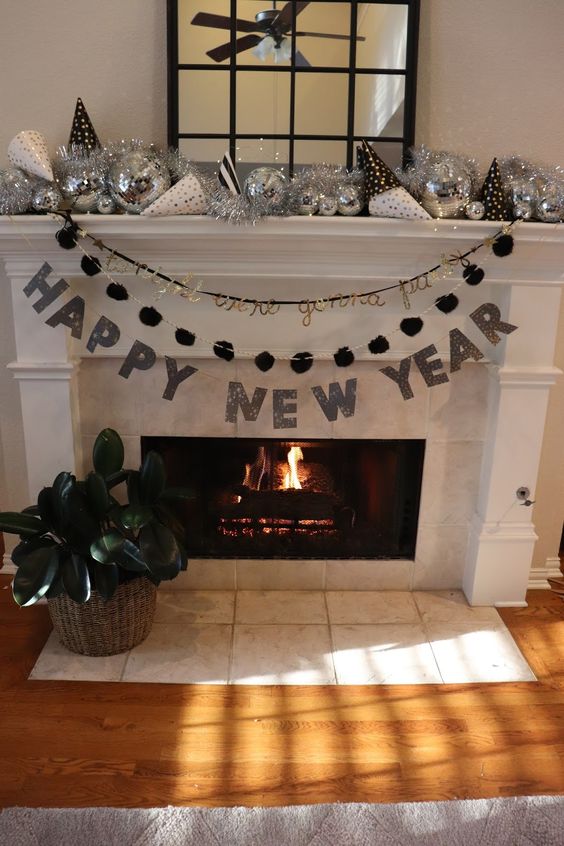 a monochromatic NYE mantel with garlands, disco balls, cones and tinsel is a cool solution for the holidays