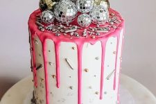 a party cake with sprinkles, pink drip and silver and gold disco balls on top is awesome for NYE