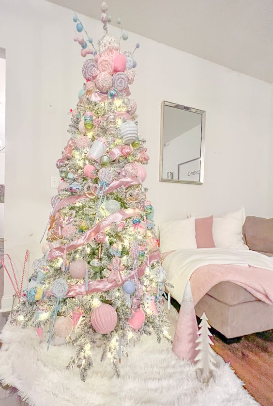 a pastel candy Christmas tree decorated with pastel blue and pink ornaments, candies, candy canes and gingerbread men is amazing