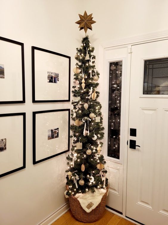 a pencil Christmas tree with lights and whimsical neutral ornaments plus a star topper is great for an entryway