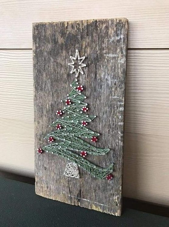 a piece of reclaiemd wood got a new life with a string art showing a lovely Christmas tree with red ornaments