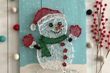 a pretty Christmas string art piece with a snowmen that is semi sheer is a lovely and catchy decor idea