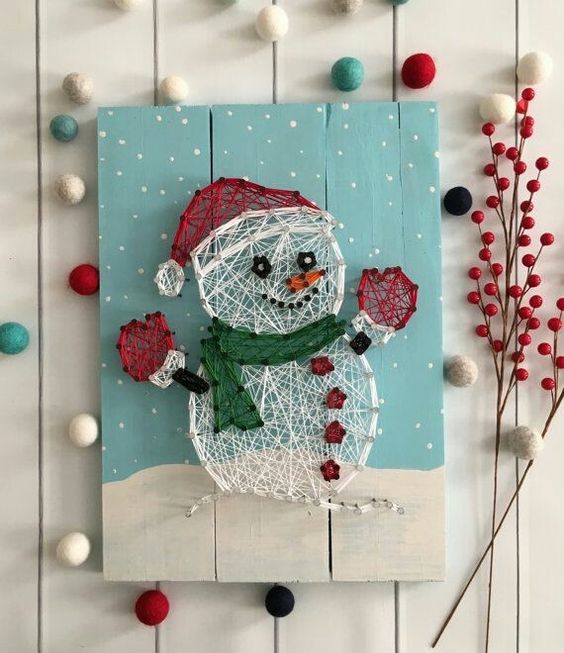 a pretty Christmas string art piece with a snowmen that is semi sheer is a lovely and catchy decor idea