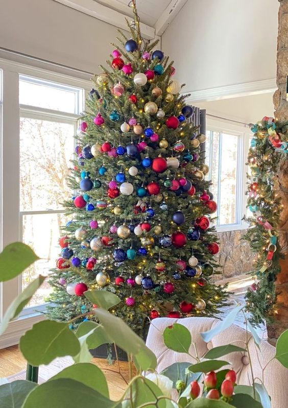 a pretty Christmas tree decorated with colorful ornaments of various sizes and shades is amazing