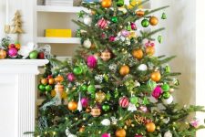 a pretty and bold Christmas tree with lights, green, orange and pink ornaments is a fun and cool solution