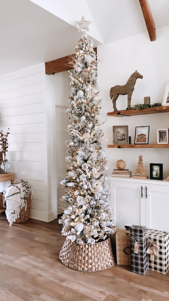 a pretty flocked pencil Christmas tree decorated with branches, lights and silver and white ornaments