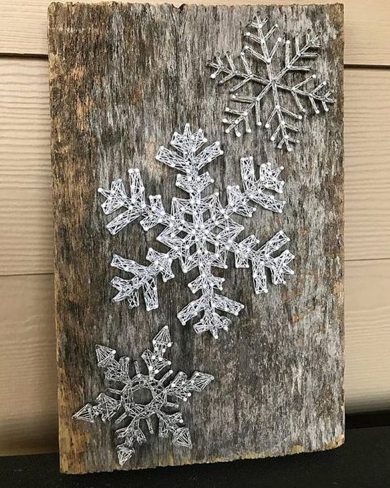 a reclaimed wood piece with string art silver snowflakes looks very cool as reclaimed wood adds interest and texture