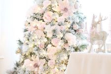 a refined and delicate Christmas tree decorated with blush faux blooms, silver ornaments and lights is adorable