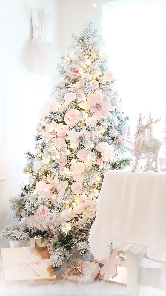a refined and delicate Christmas tree decorated with blush faux blooms, silver ornaments and lights is adorable