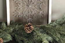a rustic Christmas string art with a snowflake done with neutral strings in a delicate way