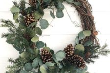 a rustic Christmas wreath with eucalyptus, evergreens and pinecones is a lovely and cozy decor idea to rock