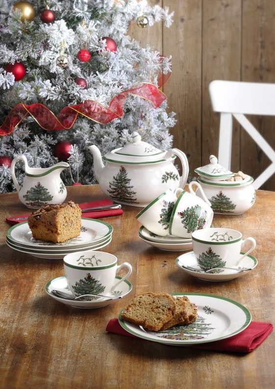 a simple Christmas tea party table with printed mugs and teaware on the whole and a Christmas cake served