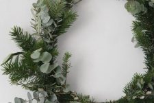 a simple and lovely Christmas wreath covered with evergreens and eucalyptus is a beautiful winter decor idea that will be actual after Christmas, too