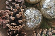 a simple and quick Christmas centerpiece of a wooden bowl, pinecones and mercury glass ornaments is a lovely idea