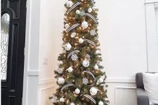 a skinny Christmas tree decorated with white ornaments and snowflakes plus black and white ribbon all over