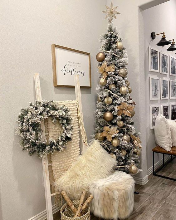 a skinny flocked Christmas tree decorated with beautiful metallic ornaments and faux blooms is wow
