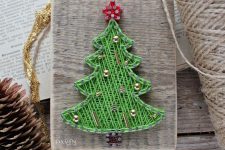 a small Christmas string art piece done with green string and gold beads is a cool decoration or an ornament