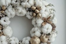 a soft cotton Christmas wreath with twigs, nuts and gilded pomegranates