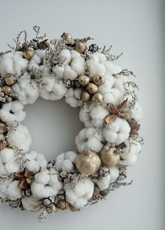 a soft cotton Christmas wreath with twigs, nuts and gilded pomegranates