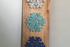a stylish Christmas string art of a white, aqua and navy snowflakes si a cool and catchy decoration