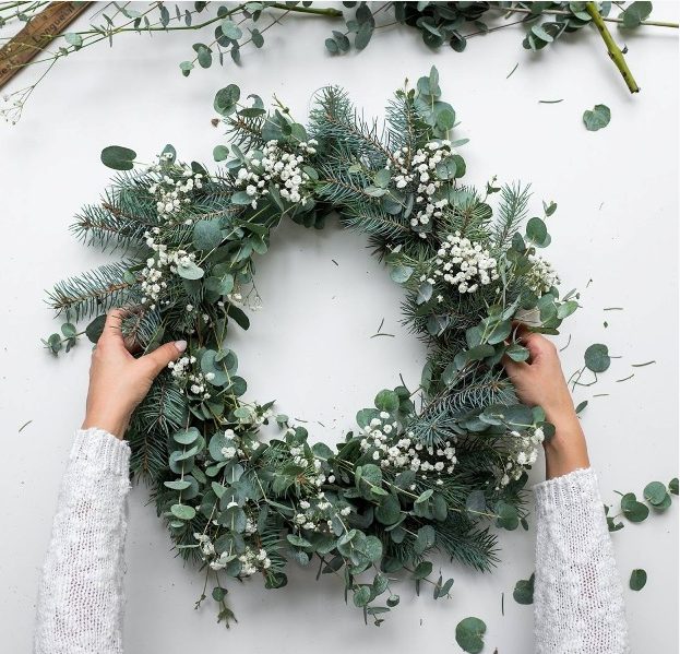 a stylish modern Christmas wreath of evergreens, eucalyptus and baby's breath is a beautiful and textural idea