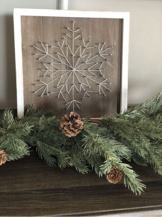 a subtle Christmas string art showing a snowflake done with neutral string is a very cool idea for a rustic space