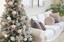 a subtle flocked Christmas tree decorated with blush and silver ornaments, snowflakes and stars looks very cool