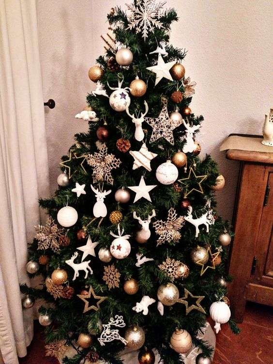 a super glam Christmas tree with white and twine stars, white, gold and brown ornaments, pinecones and a snowflake on top