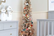 a tinsel pencil Christmas tree decorated with colorful pompoms and ornaments is a cool idea for a kids’ room