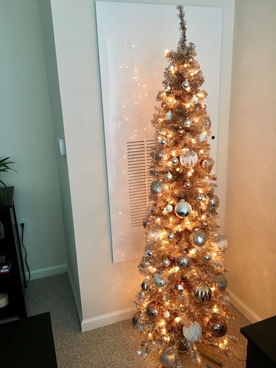 a tinsel skinny Christmas tree with lights and metallic ornaments will bring a touch of shine to the space