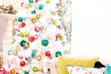a white Christmas tree decorated with colorful ornaments is a fun and bold decor idea that rocks