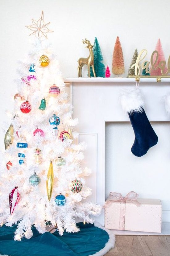 a white Christmas tree decorated with colorful vintage Christmas ornaments and a topper is a stylish and chic idea