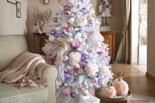 a white Christmas tree styled with oversized peonies, pastel pink and lilac ornaments looks very delicate and chic