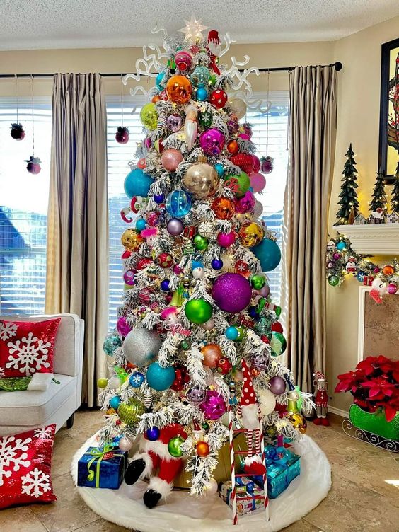 a white Christmas tree with extra bold oversized and usual ornaments is a funky and unusual solution