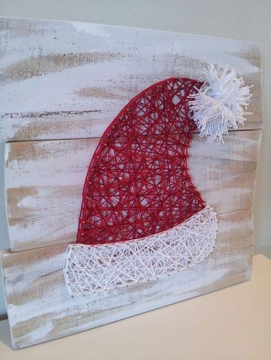 a whitewashed sign with a Santa hat in red and white looks very cute, it will be a nice artwork for the holidays