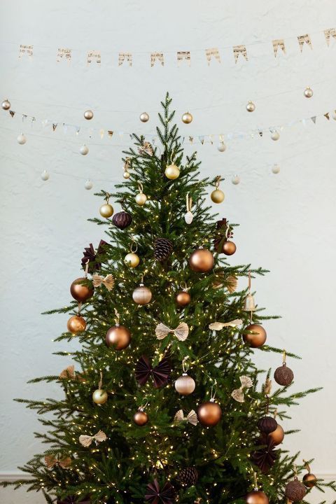 a woodland Christmas tree decorated with brown, gold and orange ornaments, pinecones and bows plus lights