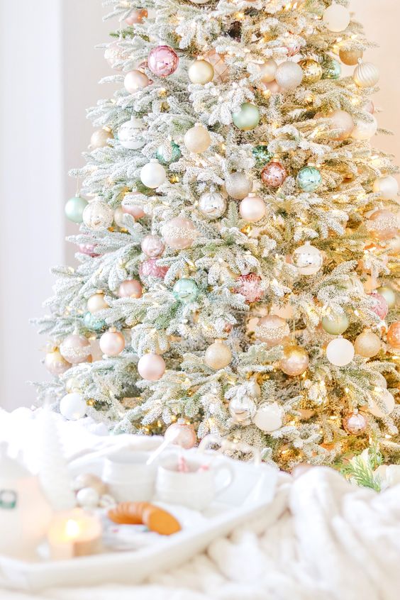 an adroable flocked Christmas tree styled with silver and pastel ornaments and lights is a cool solution for the holidays