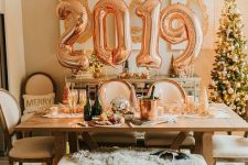 stylish NYE party decor with balloon numbers, disco balls, candles and some lanterns is awesome and can be made fast